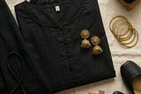 Plain black shalwar kameez with shoes, jewelry, and bag styled for versatile outfits.