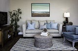 Beach themed living room with neutral sofa and wicker coffee table