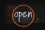Light up sign with the word open in a circle.