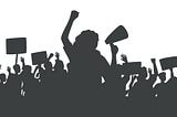 Silhouette of protesting crowd of people with raised hands and banners. Person with loudspeaker at center.