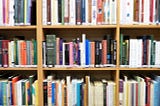 a bookshelf filled to the brim with books of all different colors, sizes, and genres