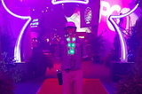 Me standing on a red carpet in front of neon Mickey Mouse ears at the 40th-anniversary party for cast members.