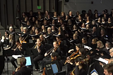 Conductor Joshua Rhode leading a performance by the Rhode Island Civic Chorale and Orchestra of We Are Phoenix by Timothy C. Takach, written in 2025.