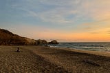 Couple meditating on the beach at sunset in Oaxaca, Mexico