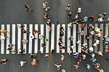 A top view photo shows many people going through the pedestrian crosswalk.