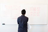 Person standing in front of white board with diagram sketches