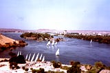 A fleet of small vessels called feluccas are crossing the Nile River in Egypt.