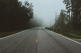 a straight road going to a foggy place