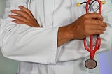 Photo of doctor holding red stethescope.