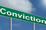 A green sign that says Conviction