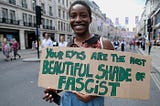 Protestor at an anti-fascism demonstration in London holds up a sign: Your eyes are the most beautiful shade of fascist