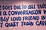 Picture of a wall with the words “This wall goes out to all those about to havea conversation with an incredibly loud friend inside and overly quiet train carriage.”