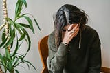 Young woman covering her face with her hand.