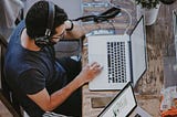 man working with headphones on computer