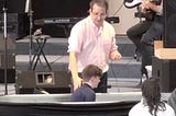 A pastor (me!) prepares to baptize a child (my son).