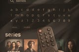 Hand holds a remote, searching for “series” on a TV screen. Letters and numbers appear above a row of show thumbnails.