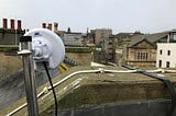 in the foreground a Wifi access point can be seen on top of a roof looking across a town