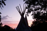 A tipi against the sunset.
