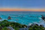 Calm evening ocean with sunset in the background