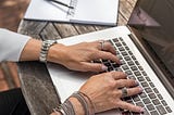 Woman’s hands placed on Mac Book Pro