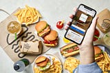 Spread of Shake Shack signature dishes with a mobile phone.