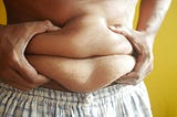 A person squeezing their bellly fat in their hands