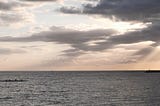 Hawaiian sunset with paddlers and clouds