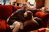 Home hospice photo of a husband and wife resting together.