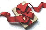 A Christmas gift wrapped with a big red ribbon