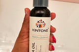 Customer holding a bottle of Kintone Batana Oil in her hand.