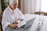 An old woman using a laptop to shop online