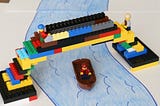 Photo of LEGO bridge as a replacement for collapsed Baltimore bridge. Humor. Funny. Construction. Ships. Sailing.