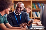 Photo of a student talking with a professor in front of a computer