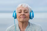 An older lady enjoying music on her headphones