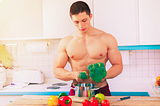 A muscular guy sorting broccoli in a cooking pan for his plant based meal — the plant based bodybuilding diet for maximum results