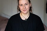 Picture of author in her home clothes, frizzy little hair horns adorning her face, relaxed and smiling