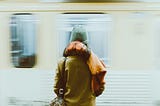 Lady on a plateform waiting for a metro to stop.