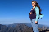 The author, pregnant, standing on a mountaintop