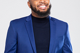 photo of Kevin Fredricks smiling in navy turtleneck and blue blazer