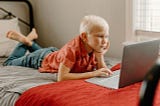 Boy on bed with laptop