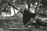 woman suspended on playground, upside down, black and white photo