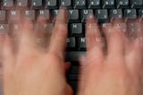 person typing furiously on keyboard