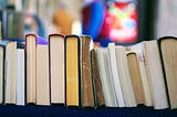 A row of books, some well-read and others appearing new.