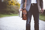 Photo of part-time instructor with book and bag