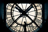 A woman is in front of an old clock