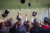 A group of graduating students through their hats in the air.