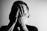 Man with his hands over his face