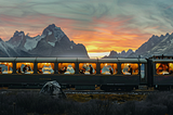An luxury railroad car dining room seen as it passes through the mountains at sunset. Inside are happy shiny people being served dinner.