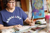 Minette in her studio, writing in her journal