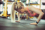 A woman doing a push-up in the gym.